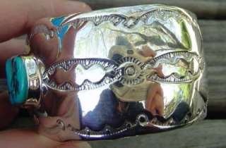 etched southwestern designs and has 3 bezel set pieces of turquoise 